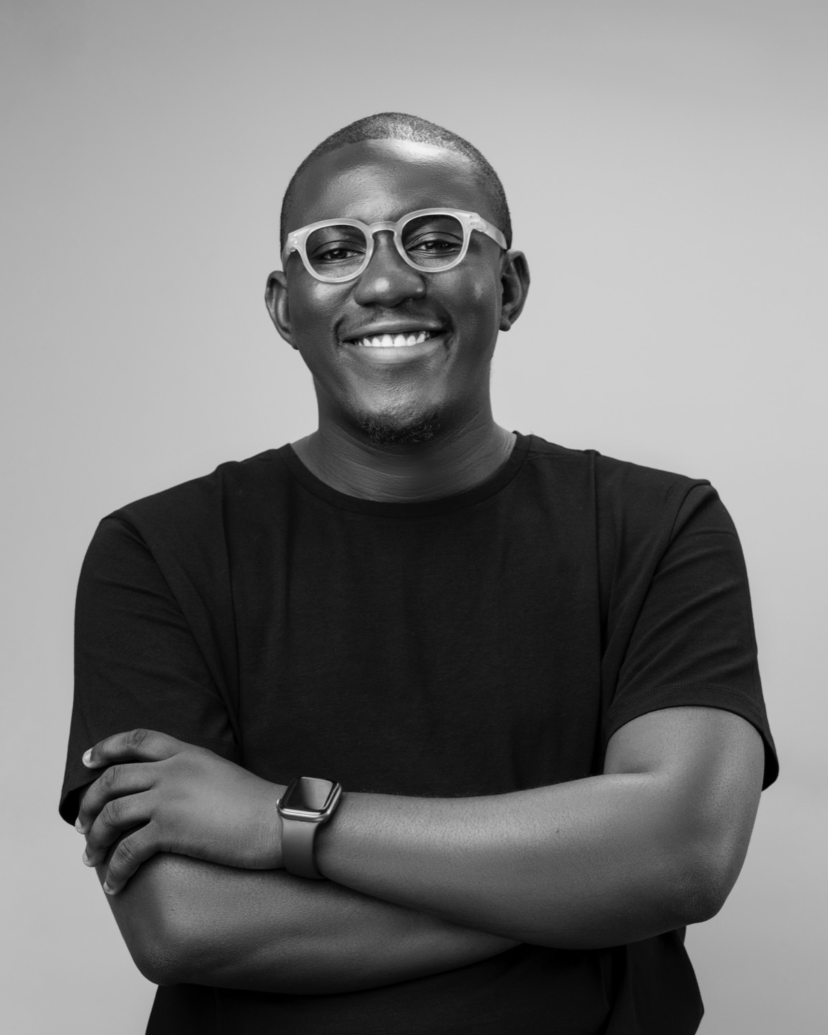Salem King with arms folded, smiling in a studio headshot