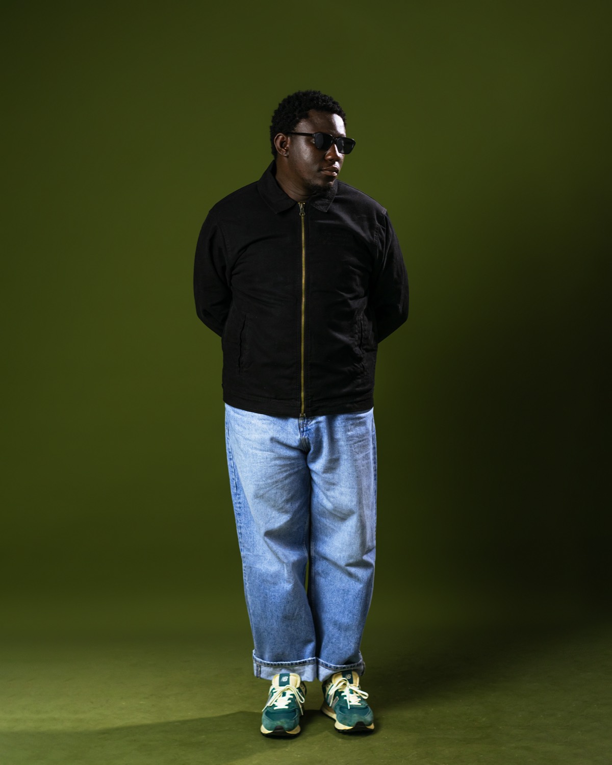 Full-length portrait of Salem King against an olive backdrop